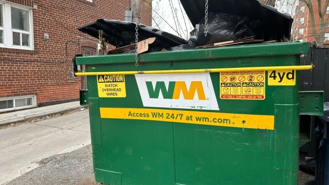 WM Hamilton green garbage bin in an alley